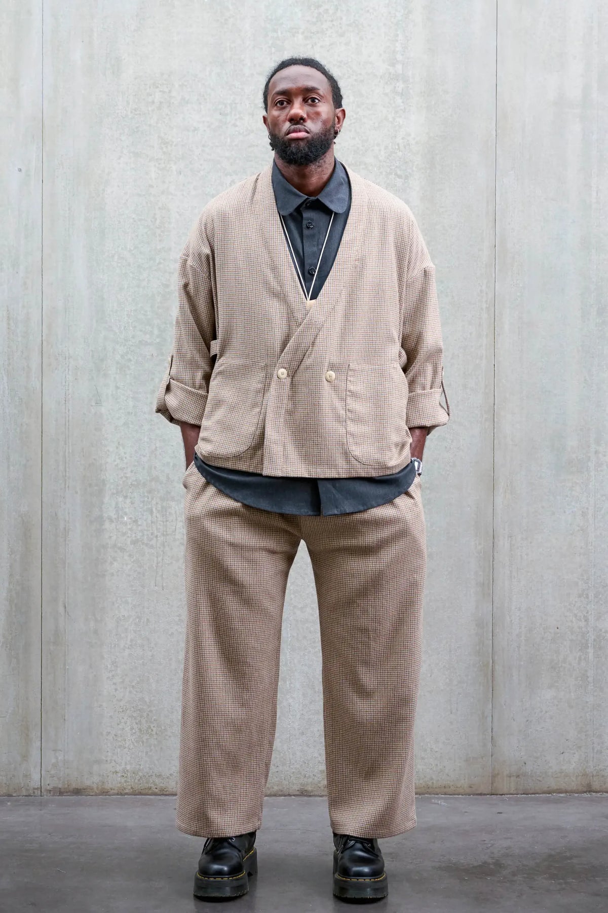 Veste oversize à col kimono de la marque Aïdama, modèle Samue en laine marron à motif pied de poule. Portée fermée par un mannequin homme et vue de face.