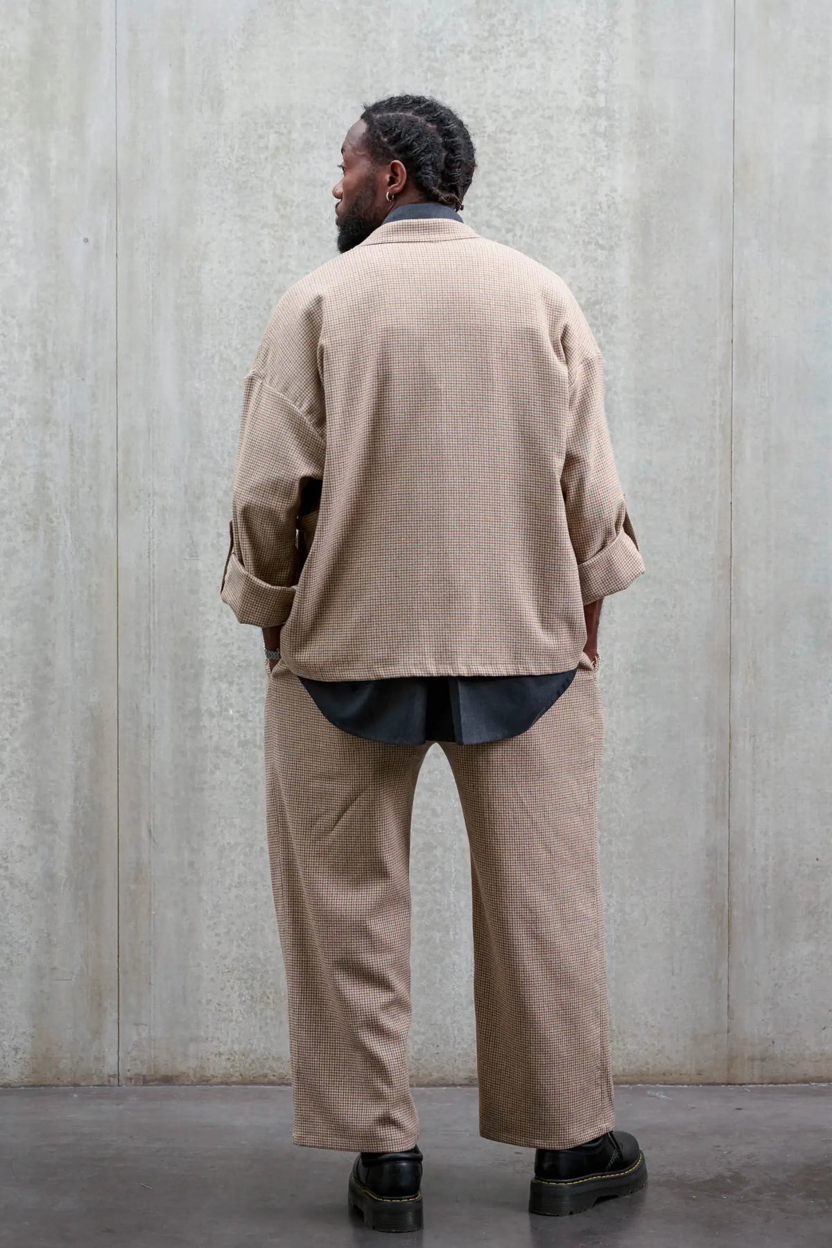 Veste oversize à col kimono de la marque Aïdama, modèle Samue en laine marron à motif pied de poule. Portée fermée par un mannequin homme et vue de dos.