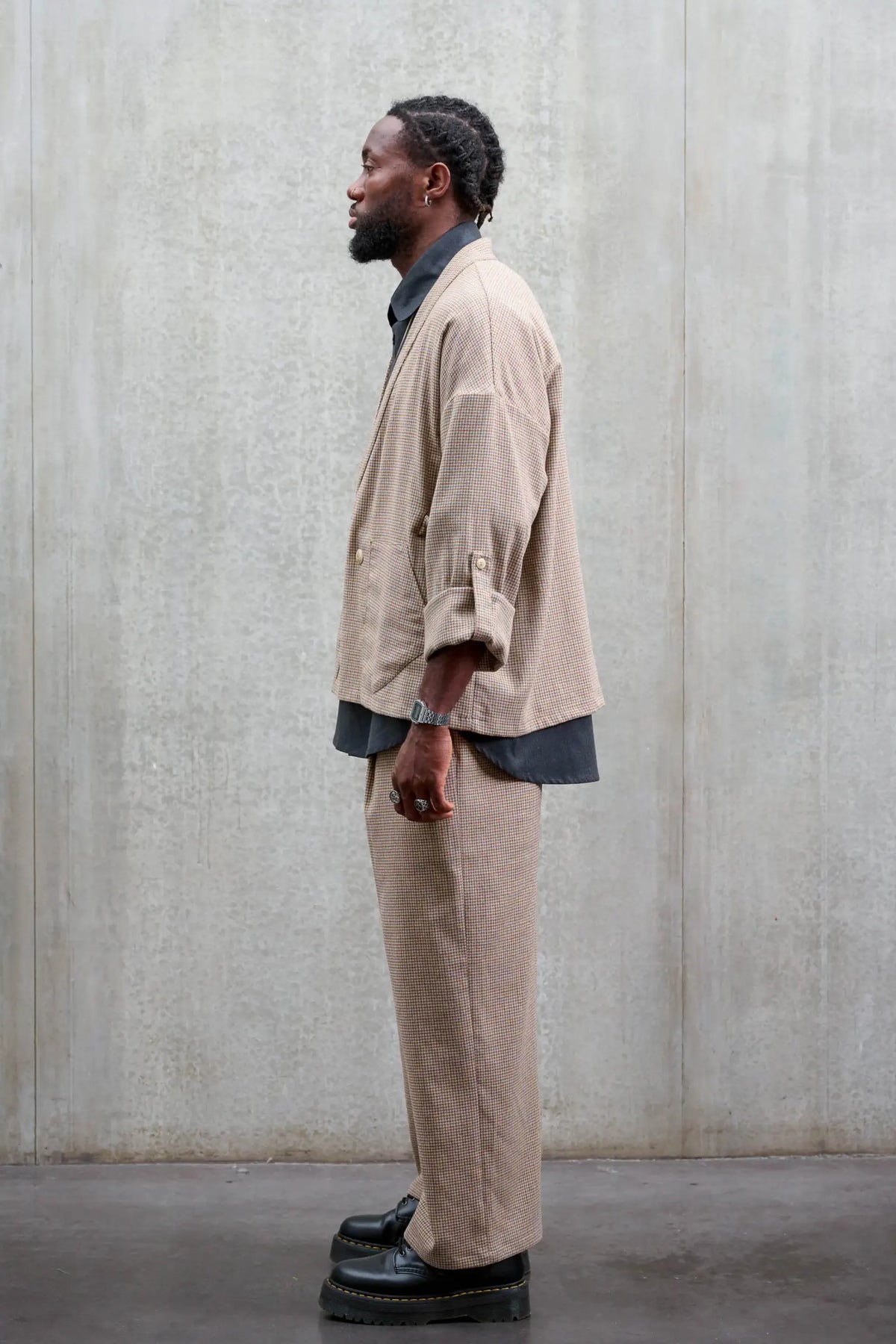 Veste oversize à col kimono de la marque Aïdama, modèle Samue en laine marron à motif pied de poule. Portée fermée par un mannequin homme et vue de profil.
