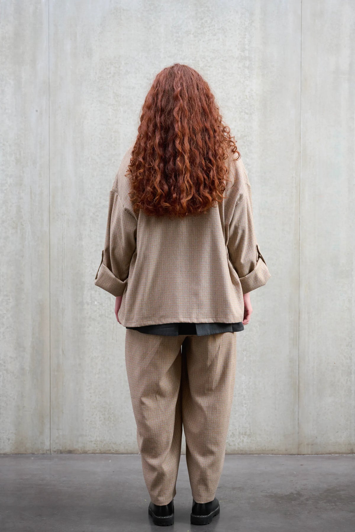 Veste oversize à col kimono de la marque Aïdama, modèle Samue en laine marron à motif pied de poule. Portée fermée par une mannequin femme et vue de dos.