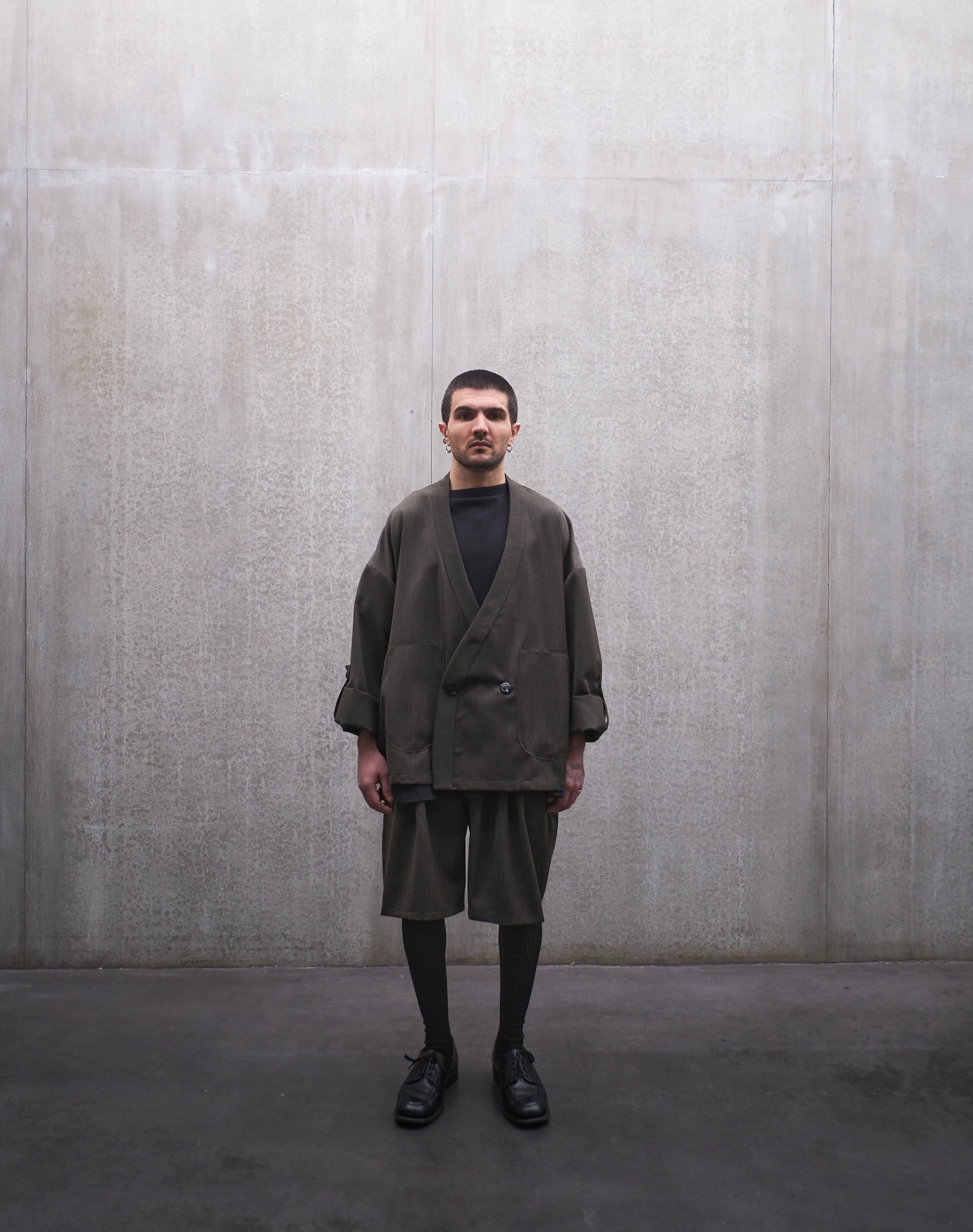 Veste croisée à col kimono Aïdama modèle Samue en laine froide vert chiné. Portée fermée par un mannequin homme et vue de face.
