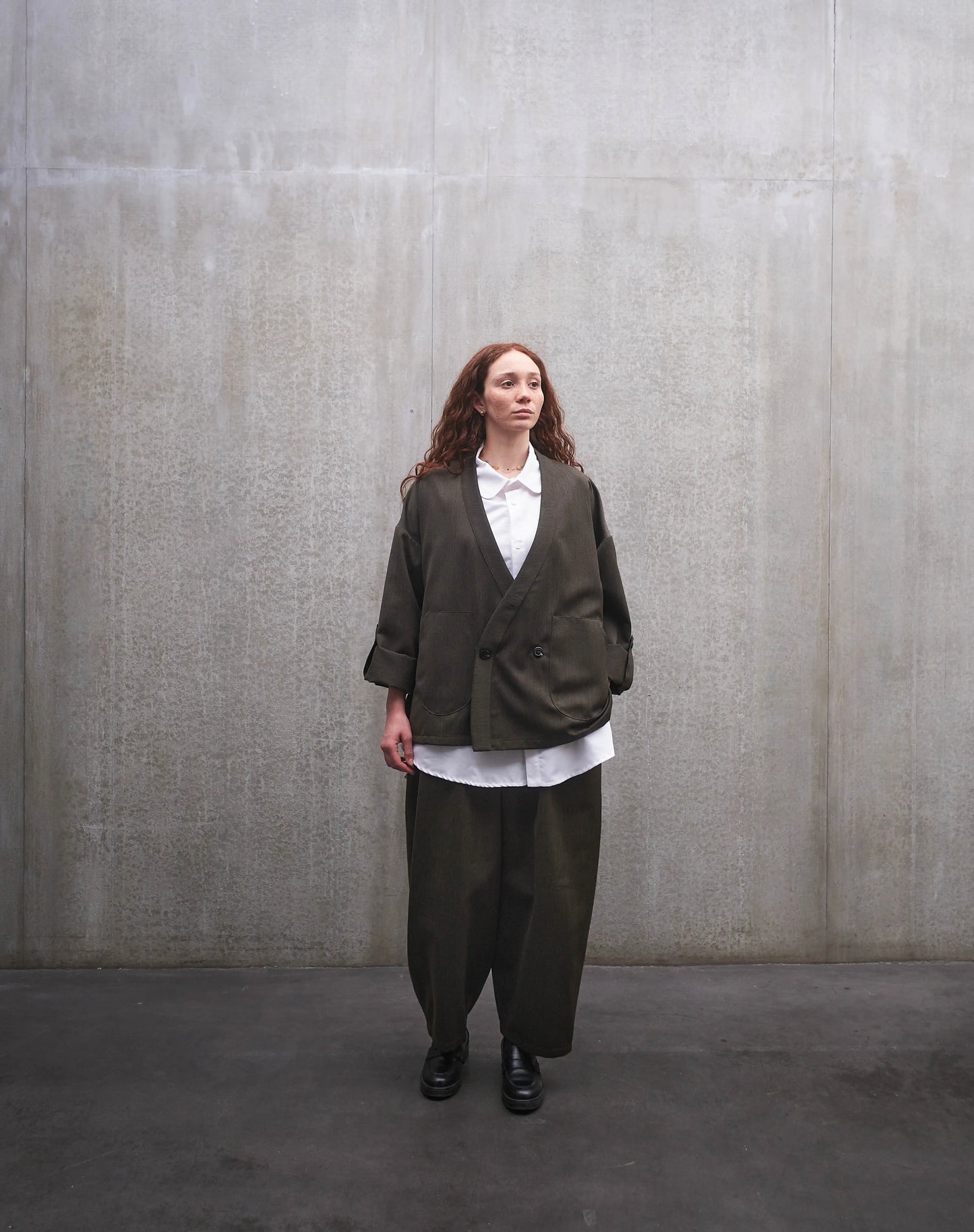 Ensemble veste samue et pantalon circulaire en laine froide vert chiné de la marque Aïdama. Portés par une mannequin femme et vus de face.