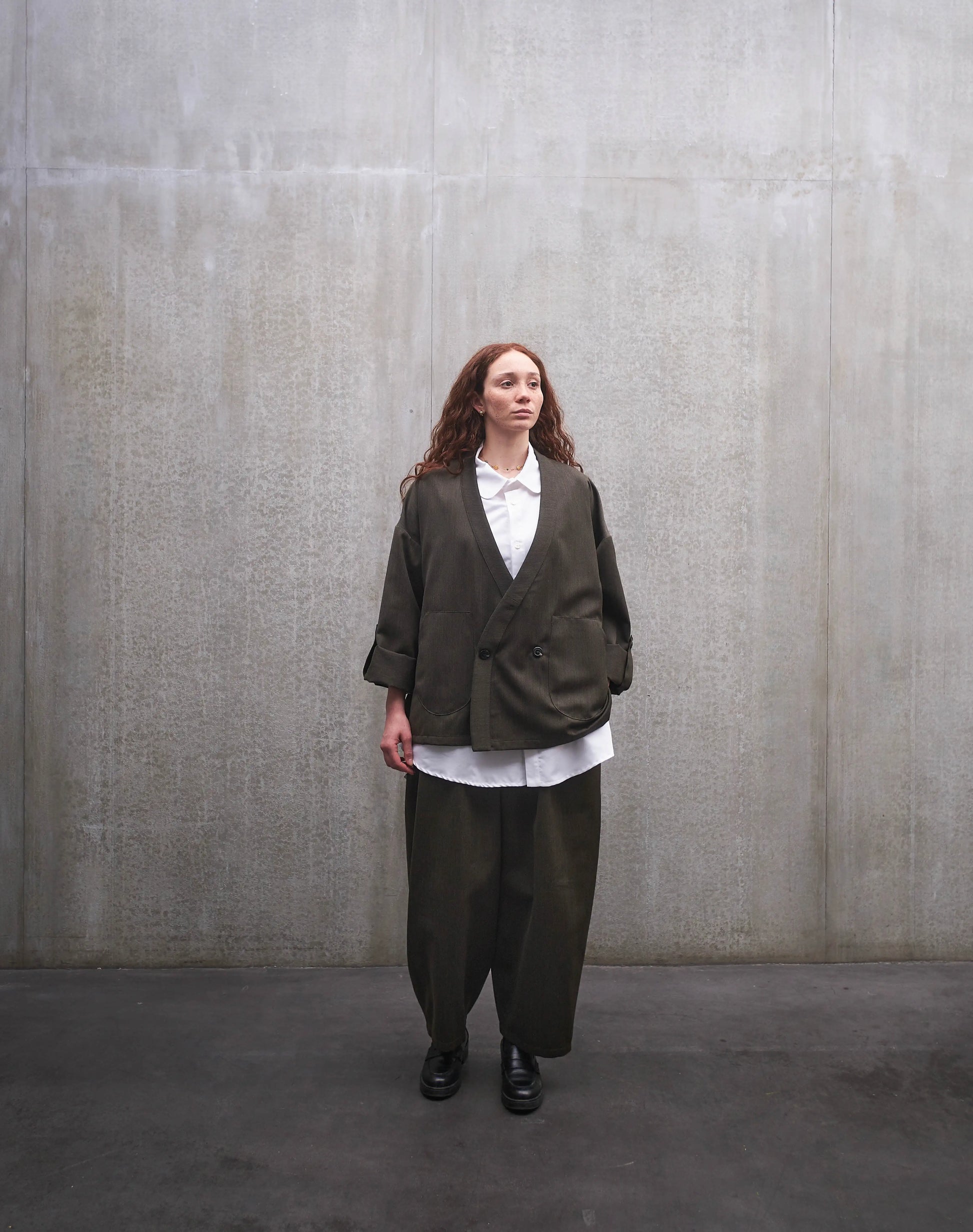 Ensemble veste samue et pantalon circulaire en laine froide vert chiné de la marque Aïdama. Portés par une mannequin femme et vus de face.