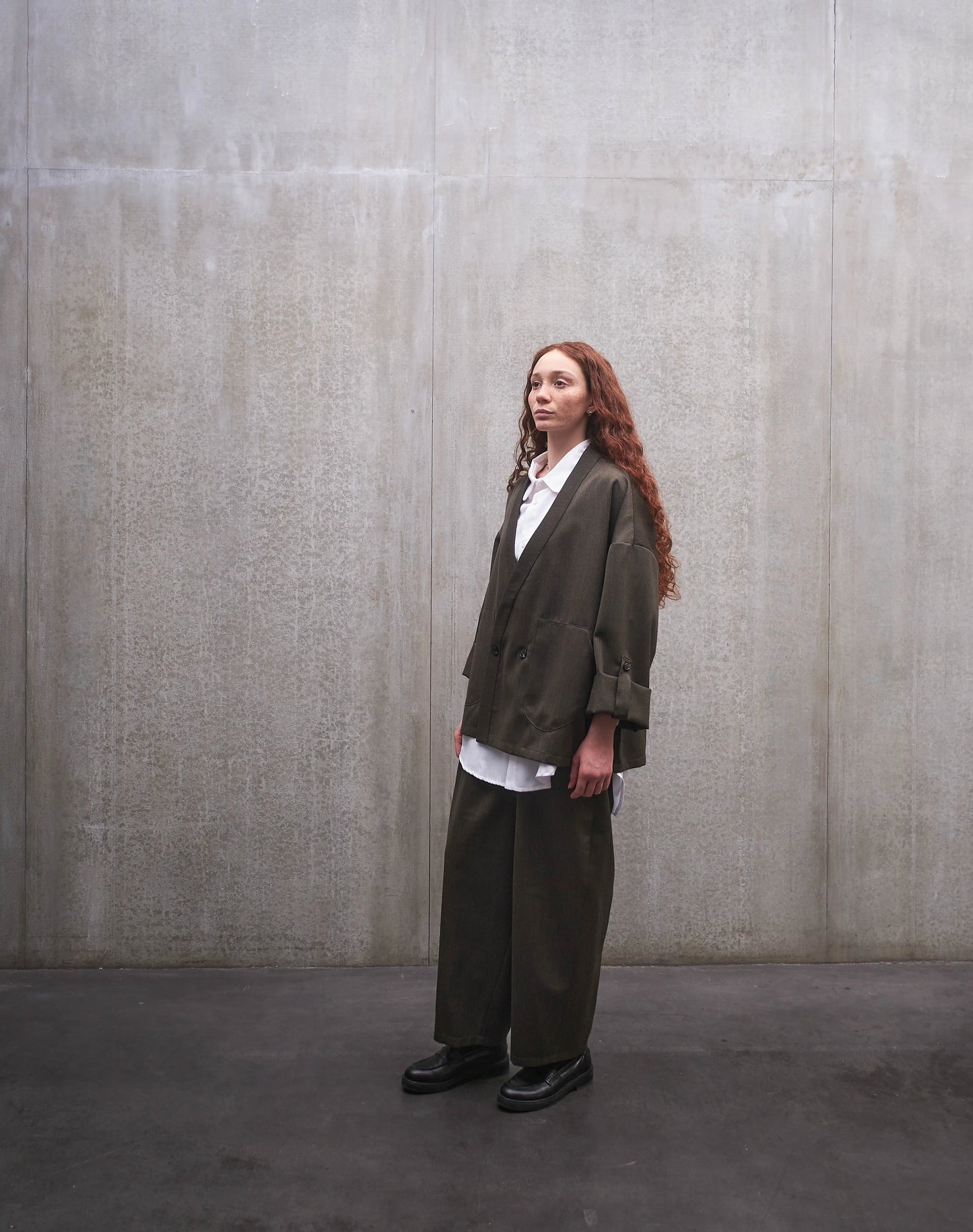 Veste croisée à col kimono Aïdama modèle Samue en laine froide vert chiné. Portée fermée par une mannequin femme et vue de trois quarts.
