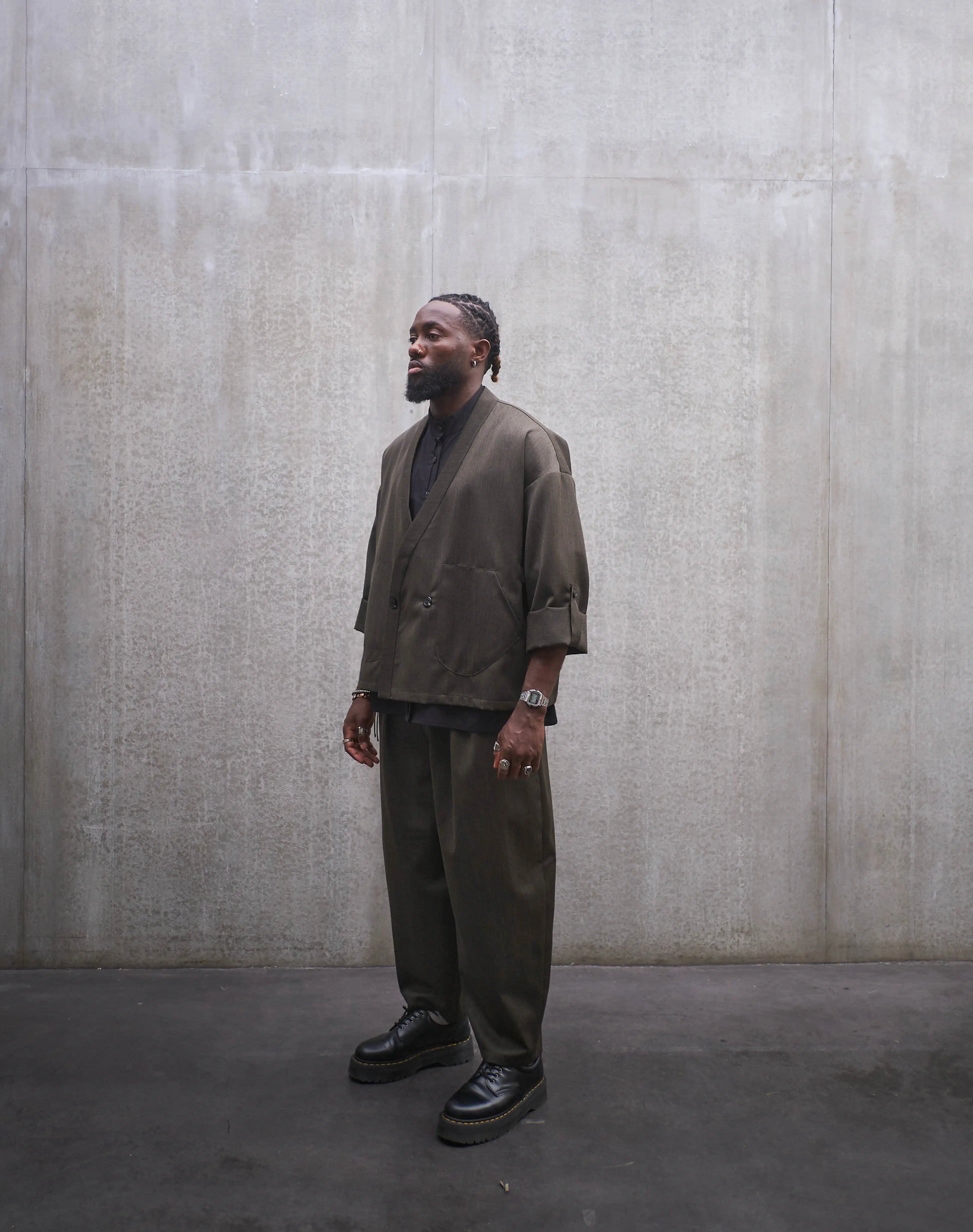 Veste croisée à col kimono Aïdama modèle Samue en laine froide vert chiné. Portée fermée par un mannequin homme et vue de trois quarts.