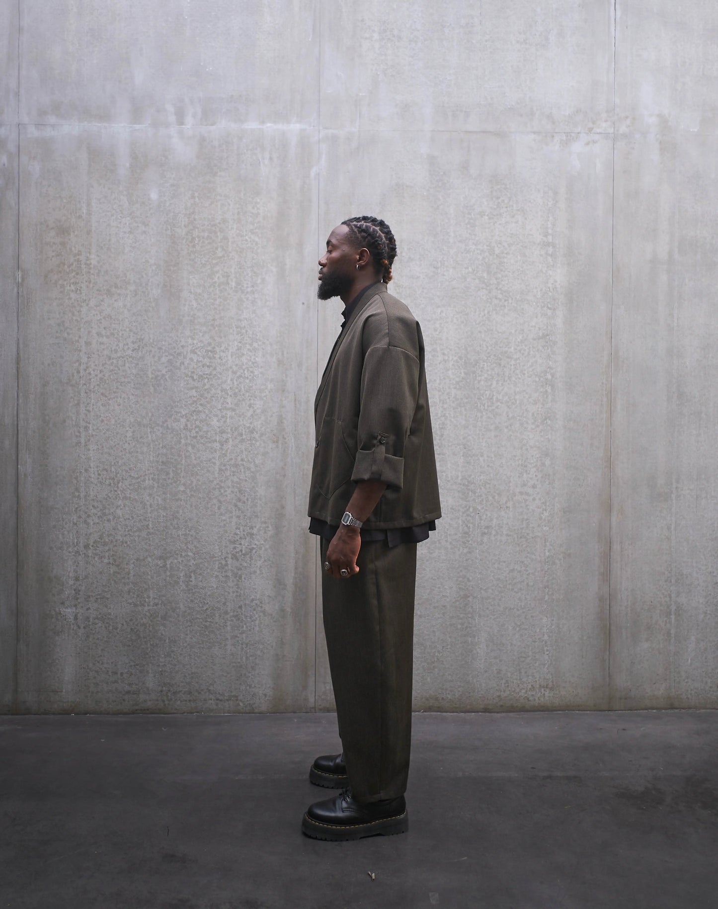 Veste croisée à col kimono Aïdama modèle Samue en laine froide vert chiné. Portée fermée par un mannequin homme et vue de profil.