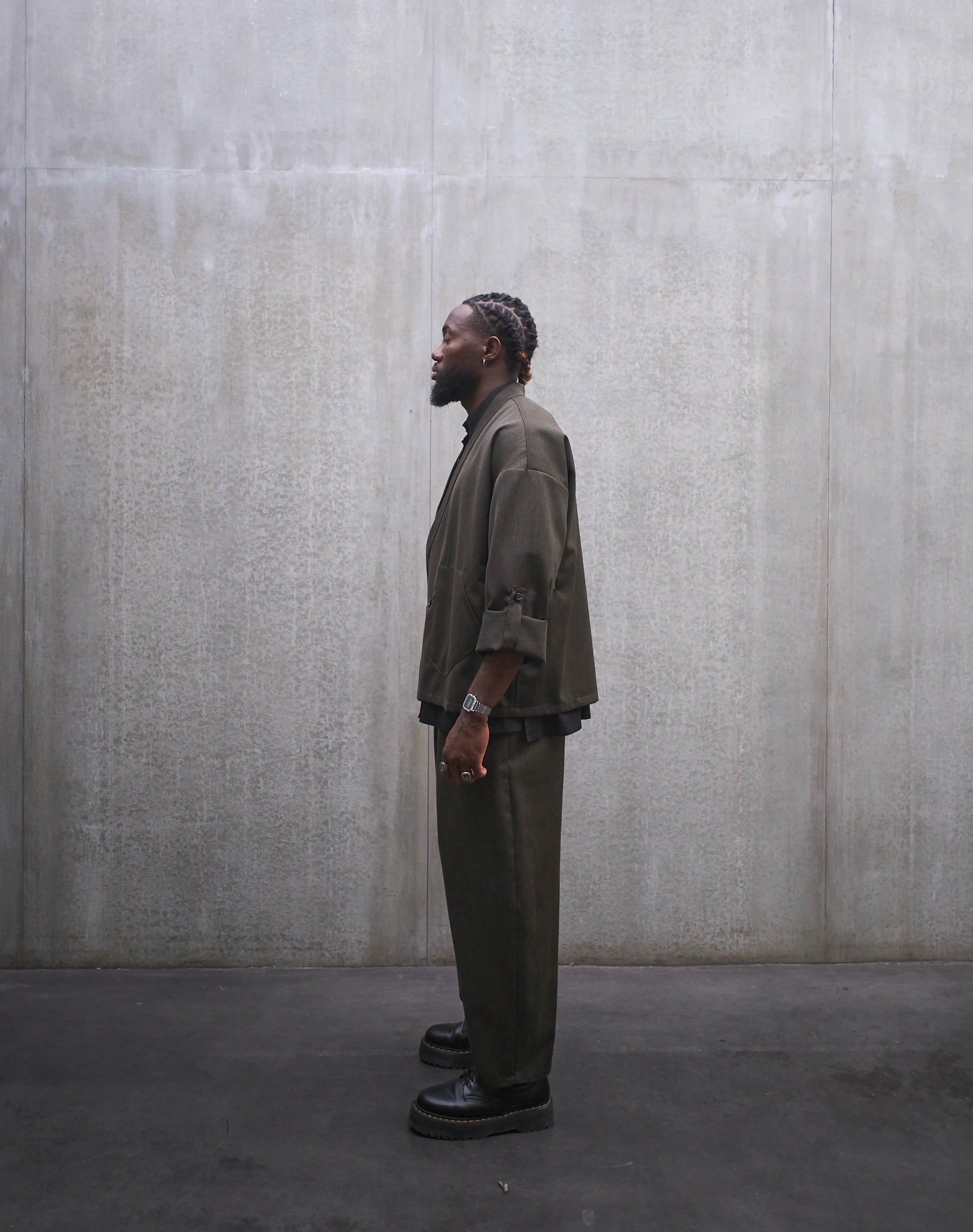 Veste croisée à col kimono Aïdama modèle Samue en laine froide vert chiné. Portée fermée par un mannequin homme et vue de profil.