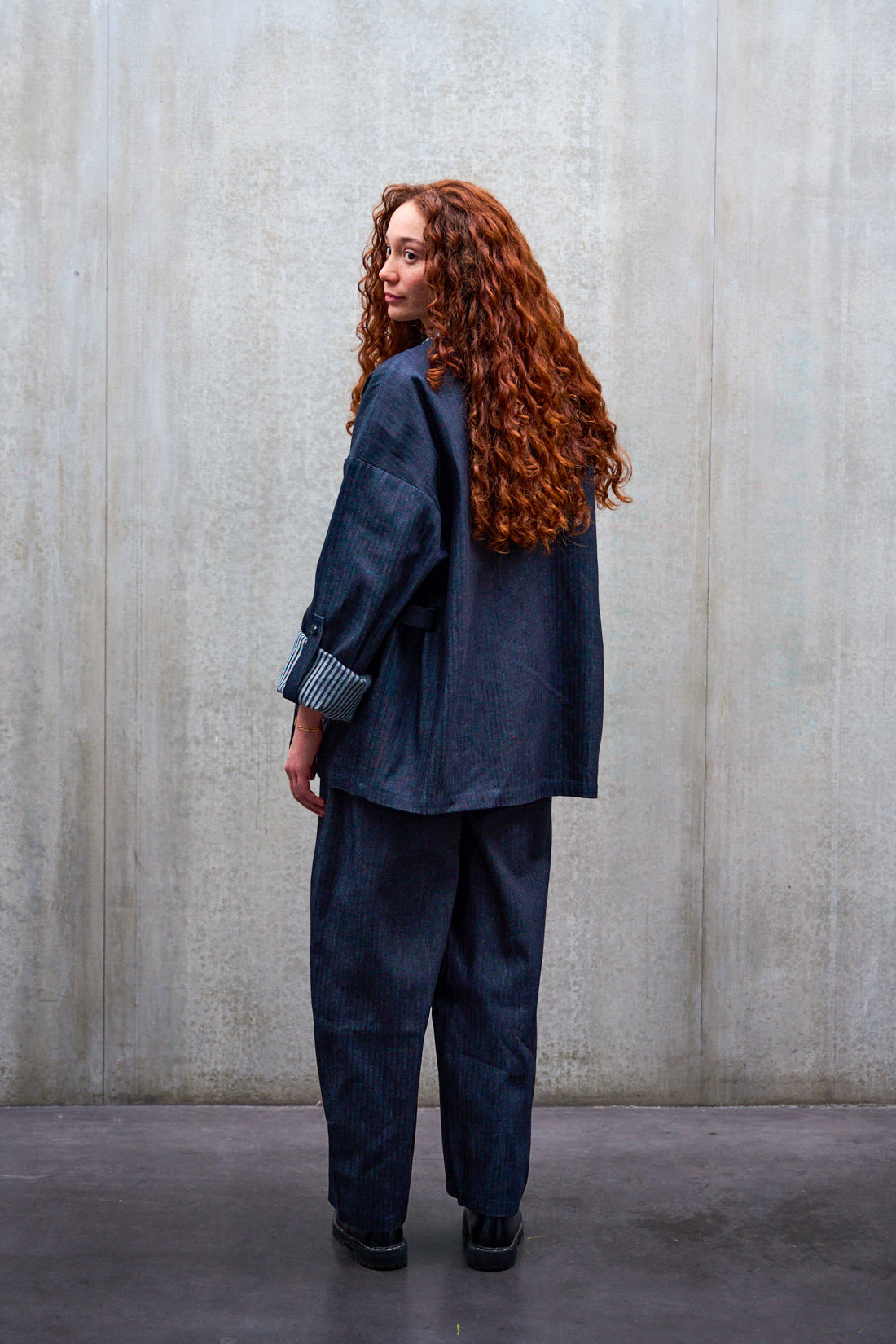 Veste croisée à col kimono Aïdama modèle Samue en denim japonais rayé. Portée par une mannequin femme et vue de dos.