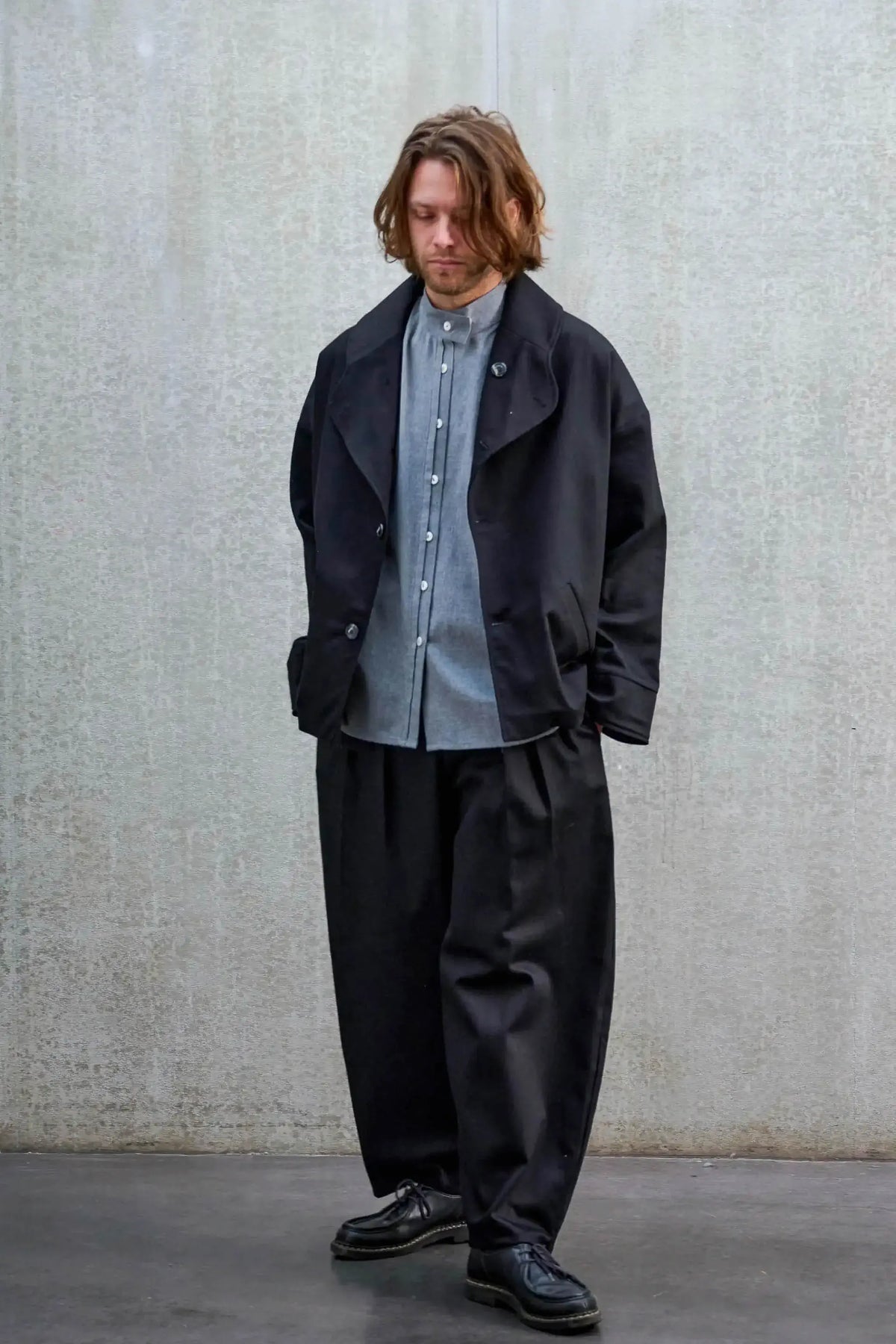 Veste oversize de la marque Aïdama, modèle Gunbai en sergé de coton noir. Portée ouverte par un mannequin homme et vue de face.