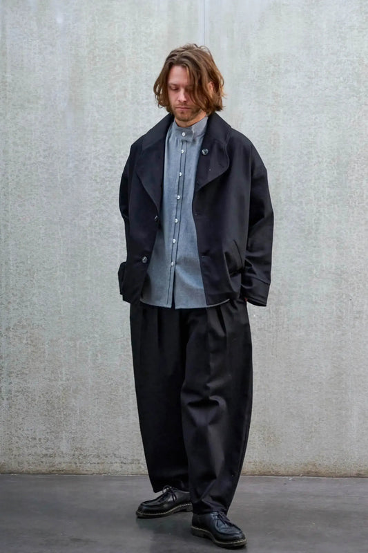 Veste oversize de la marque Aïdama, modèle Gunbai en sergé de coton noir. Portée ouverte par un mannequin homme et vue de face.