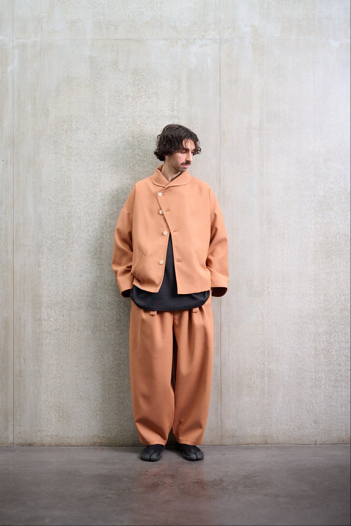 Veste oversize à col arrondi de la marque Aïdama, modèle Gunbai en coton & laine terre de sienne. Portée fermée par un mannequin homme et vue de face.