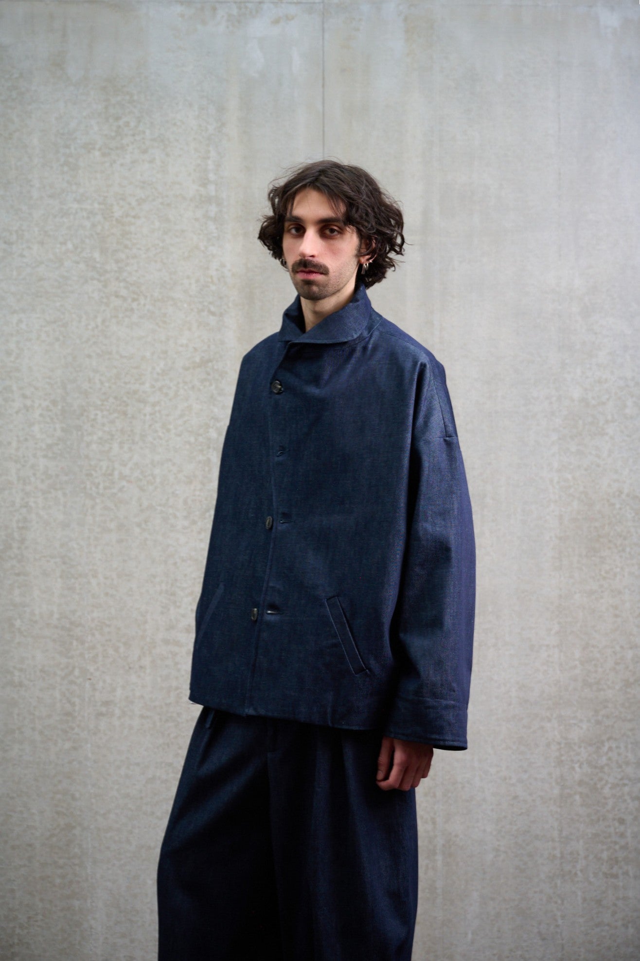 Veste oversize Aïdama modèle Gunbai en denim brut portée par un mannequin  homme, fermée et vue de trois quart.